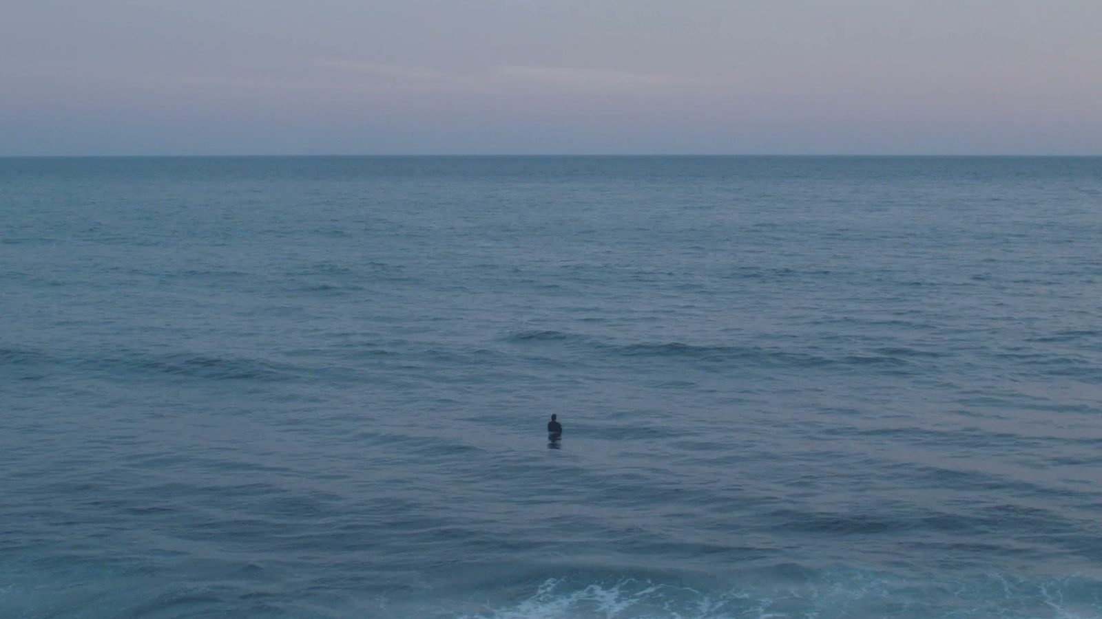 The sea at dusk, one swimmer far out